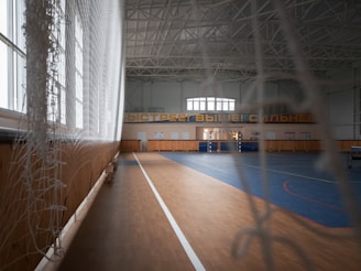 a large indoor gym with hard wood flooring
