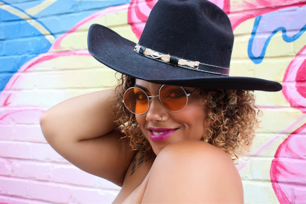a woman wearing a cowboy hat and sunglasses