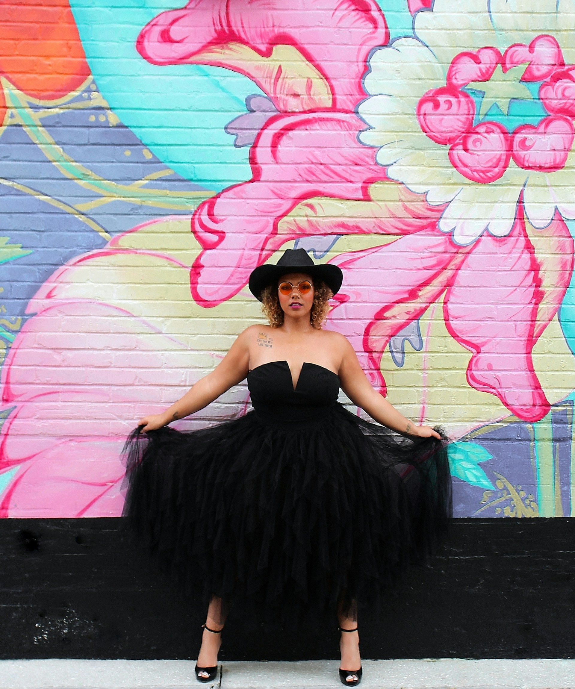 a woman wearing a black dress and a black hat