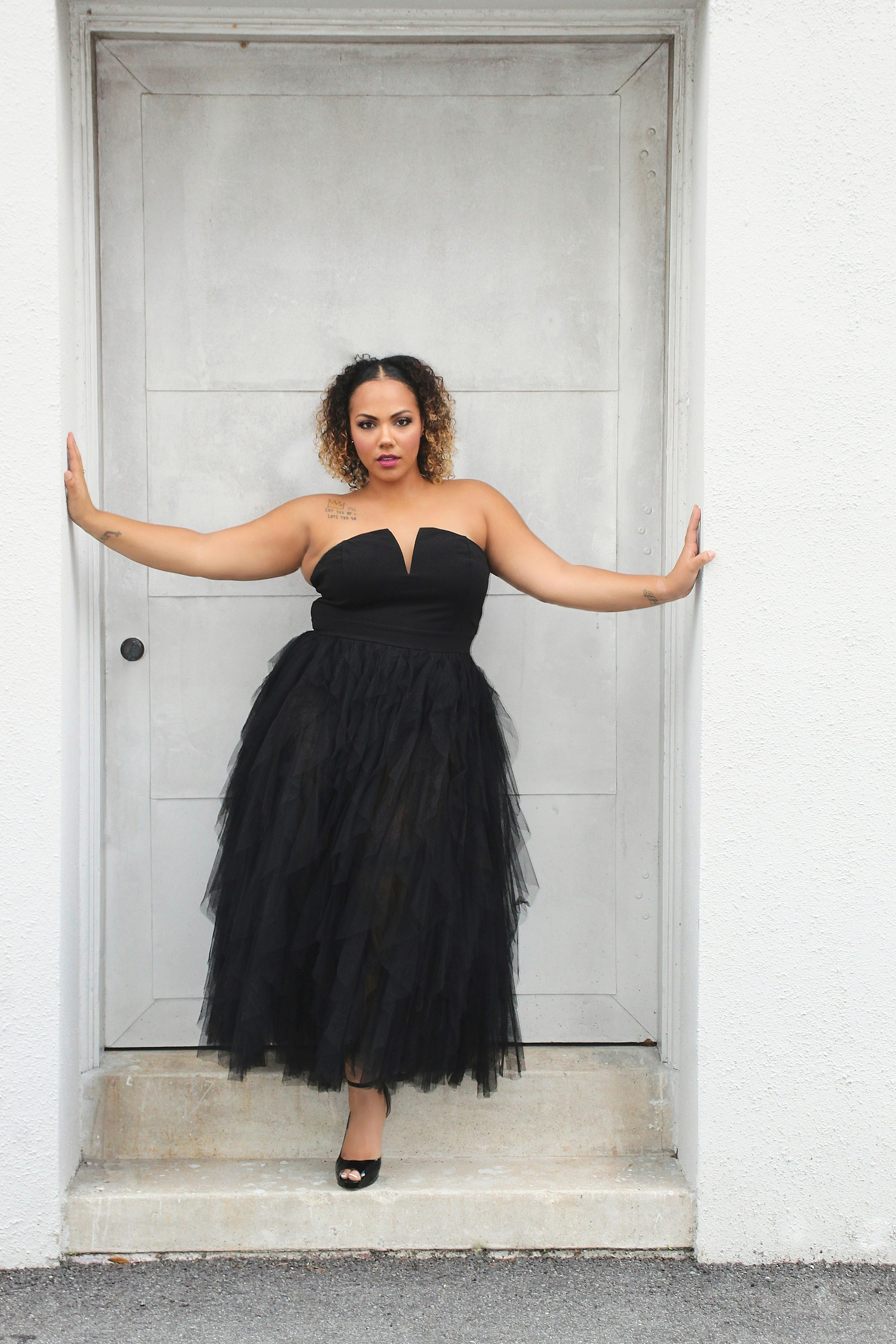 A woman in a black dress standing in front of a door photo – Free ...