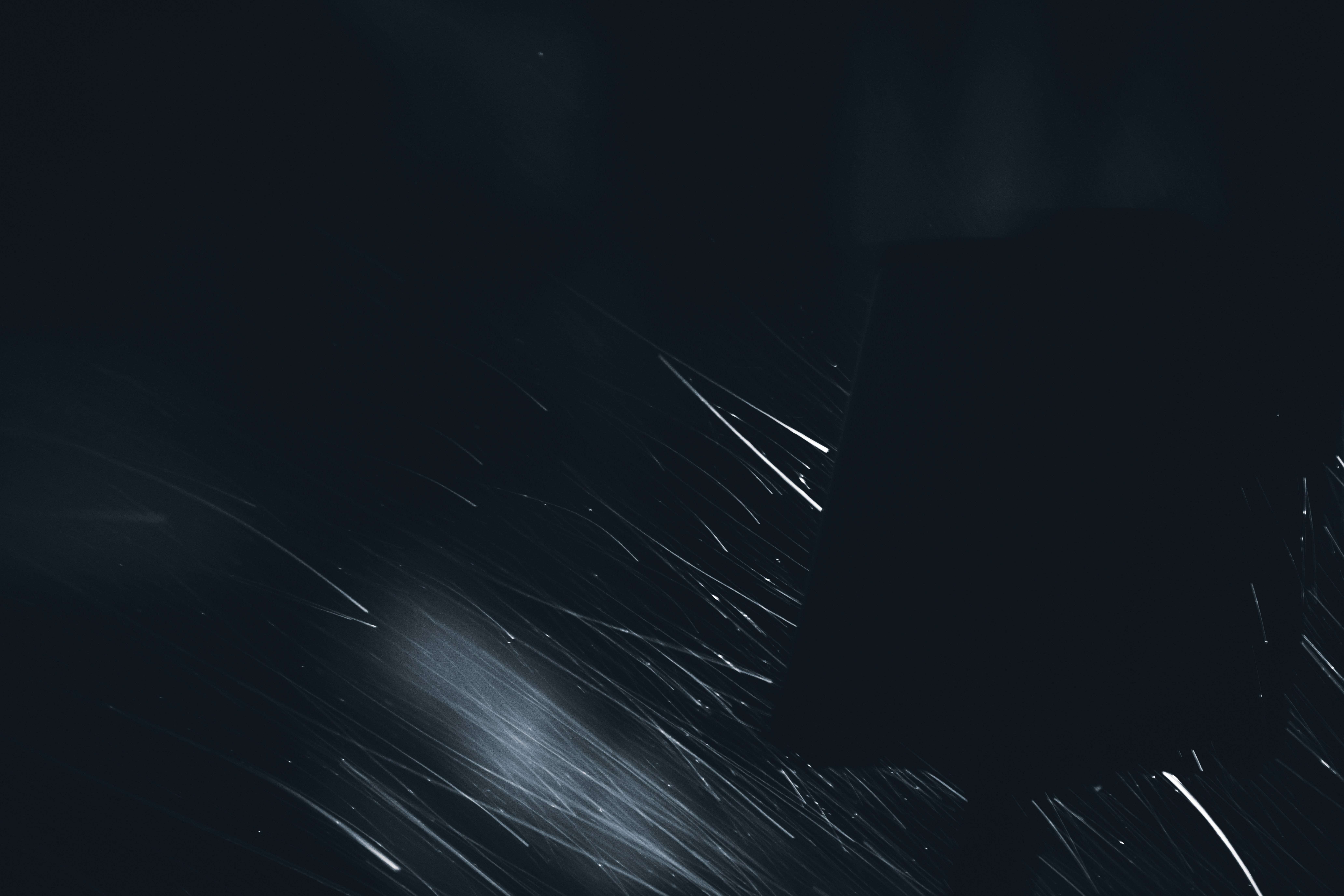 Dark cinematic scene with light streaks on black background