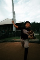 a young boy holding a baseball bat on top of a field