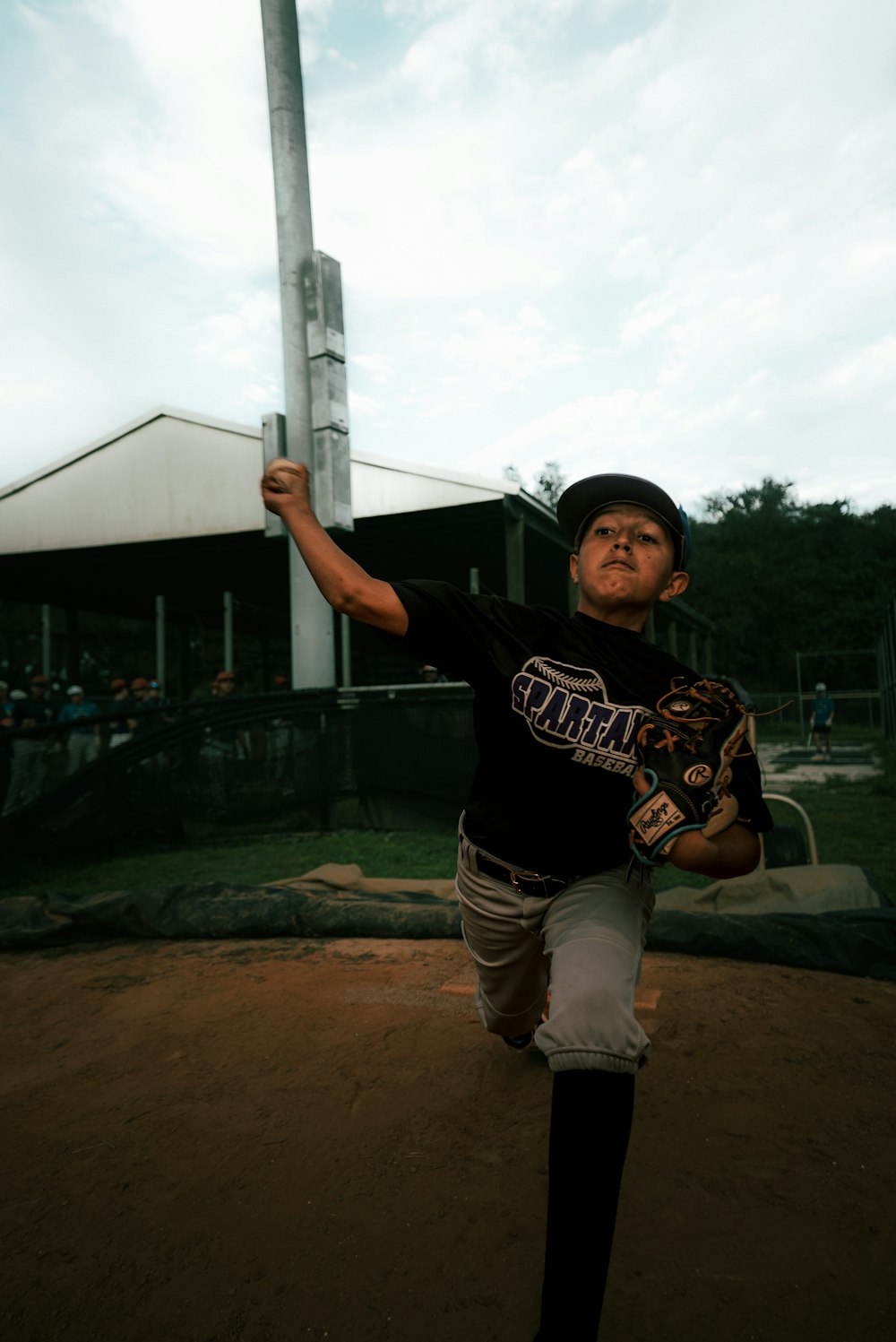 a young boy holding a baseball bat on top of a field