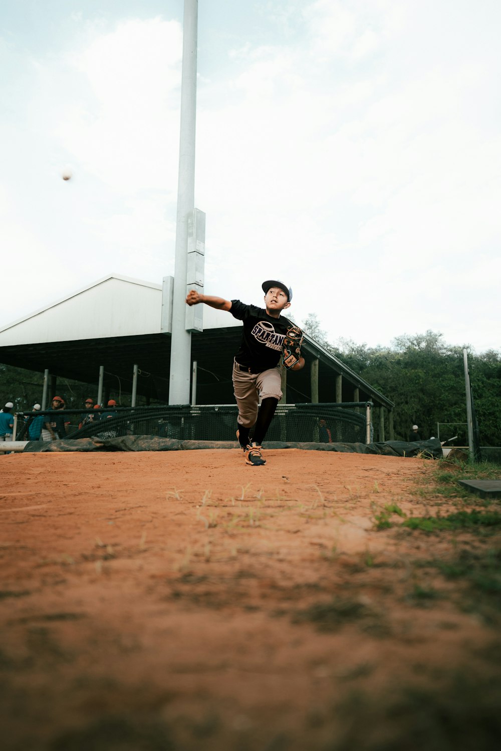 a young boy throwing a baseball on a baseball field