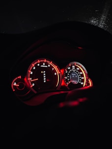 the dashboard of a car with red lights