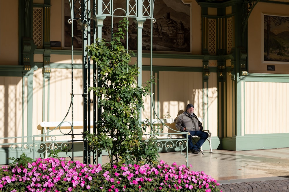 a man sitting on a bench in front of a building