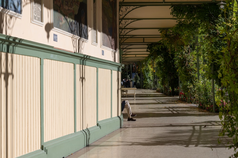 a person sitting on a bench under a building