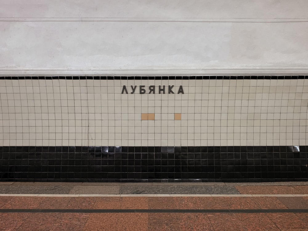 a black and white tiled wall with a name on it
