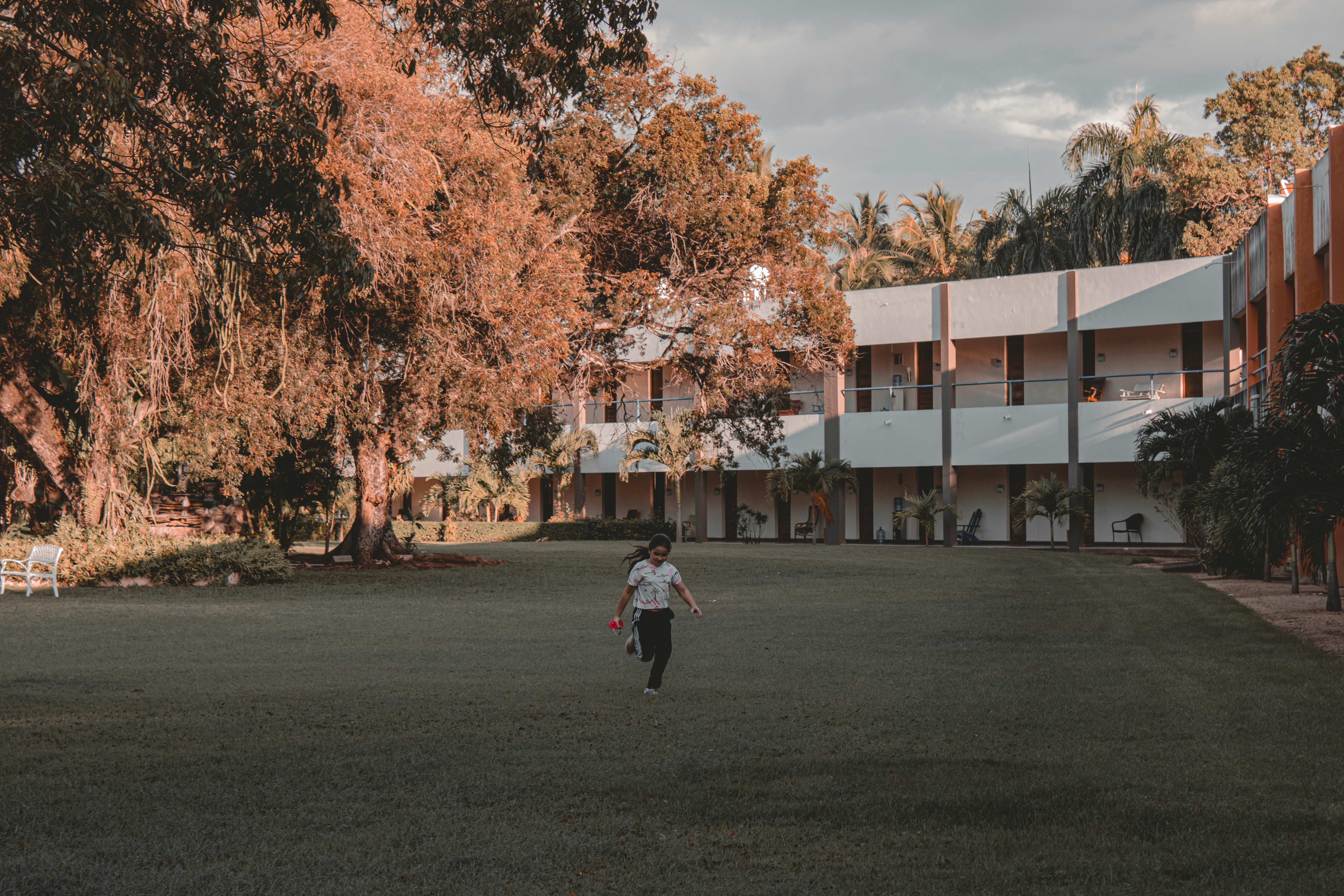 a person walking in a field near a building