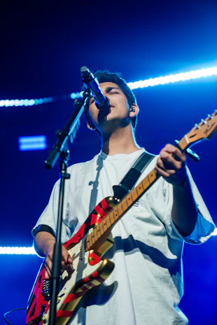Musician performing live on stage with the bim-w1 wireless system, cables-free and illuminated by stage lights.