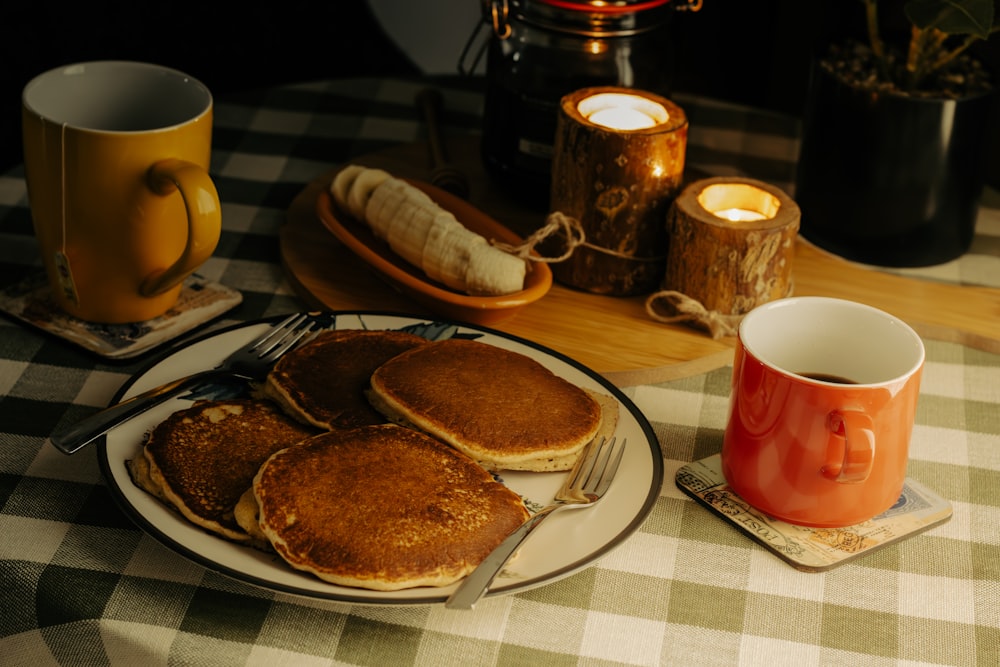 a plate of pancakes next to a cup of coffee