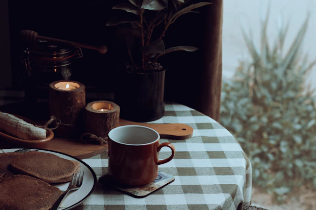 Cozy Scandinavian restaurant table set with artisanal bread and fresh farm produce under warm lighting.