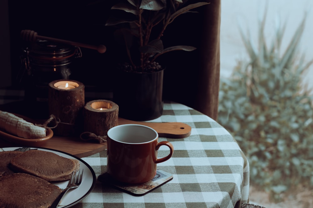 una mesa cubierta con un plato de comida y una taza de café