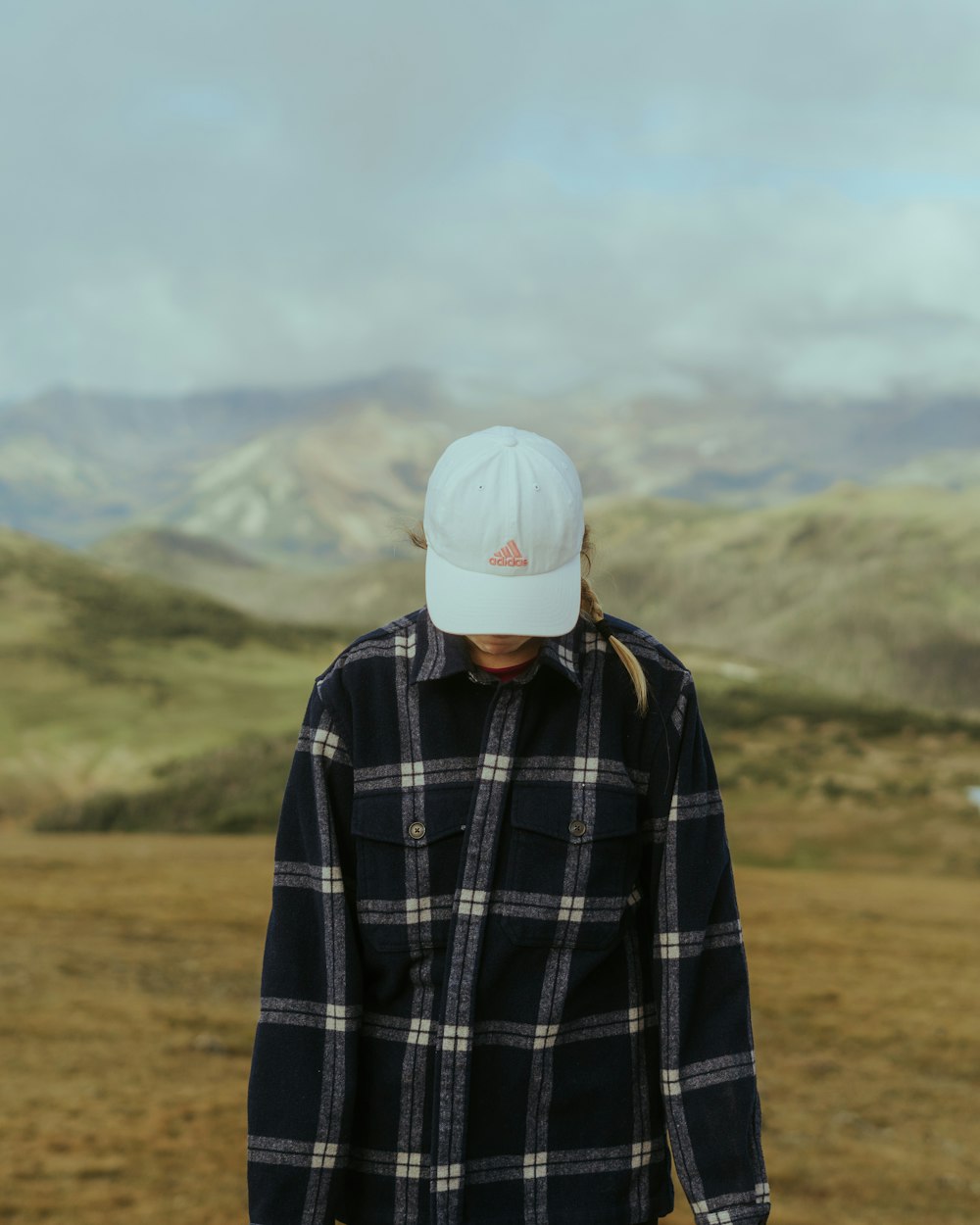 a person standing in a field with mountains in the background