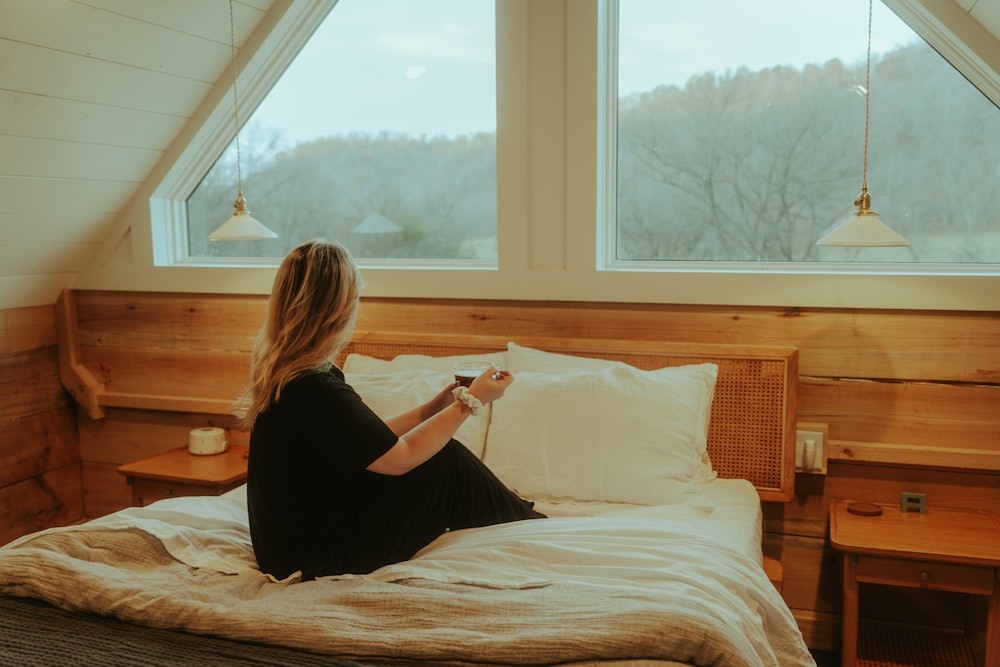 a woman sitting on a bed in a loft