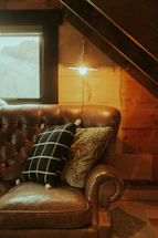 A cozy living room corner featuring a plush sofa bathed in warm natural light.