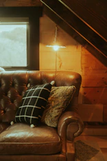 A cozy corner featuring a plush sofa with rich upholstery and a stylish floor lamp.