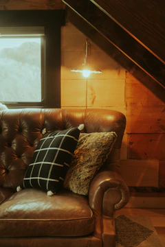 A cozy corner featuring a plush sofa with rich upholstery and a stylish floor lamp.