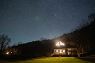 Night view of the cottages softly illuminated under a starry sky.