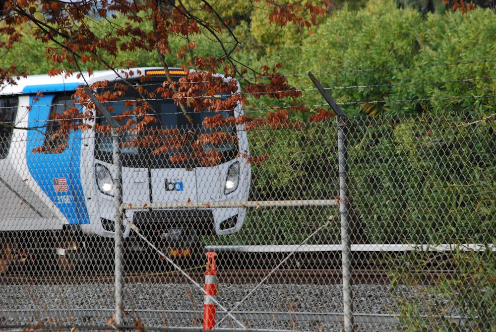 a blue and white train traveling down train tracks