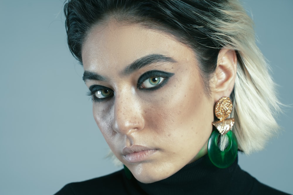 a close up of a person wearing a pair of earrings