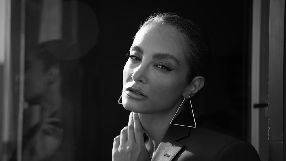 a black and white photo of a woman wearing earrings