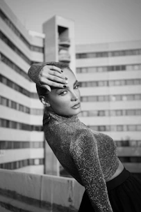 a black and white photo of a woman with her hands on her head