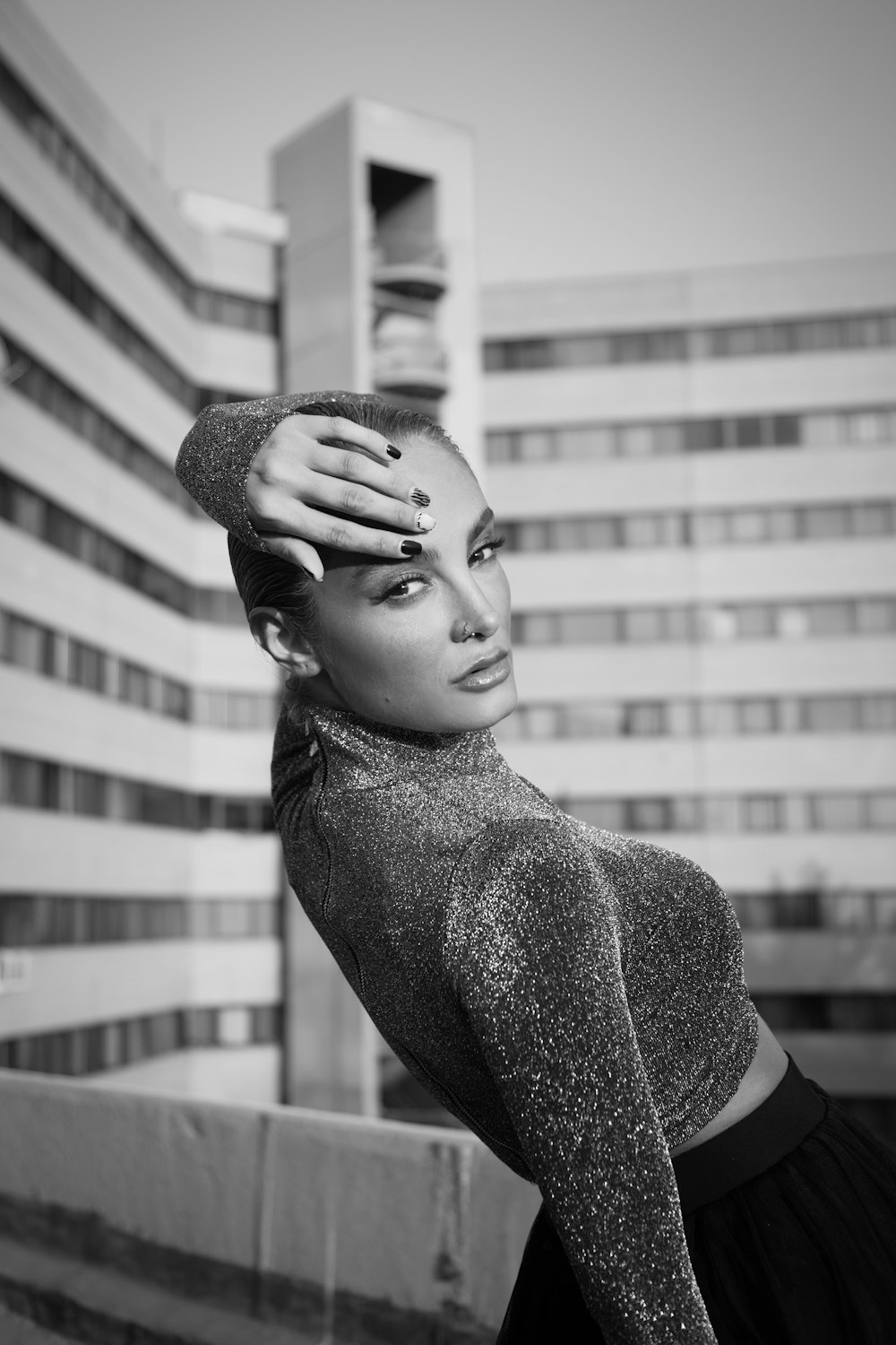 a black and white photo of a woman with her hands on her head