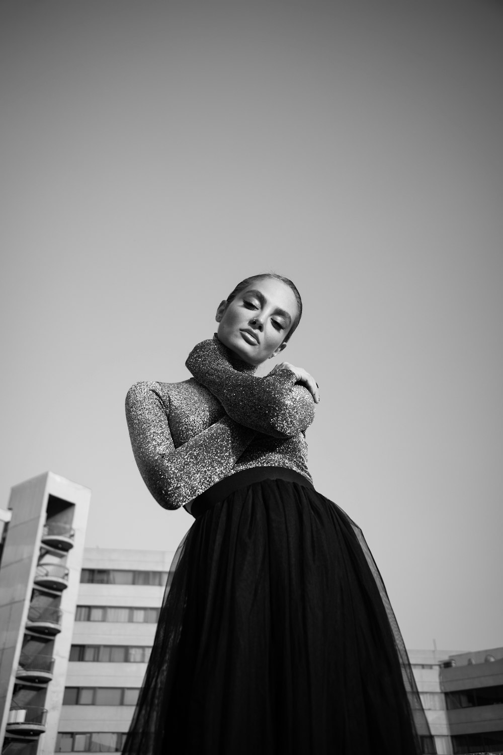 a woman in a black dress standing in front of a building