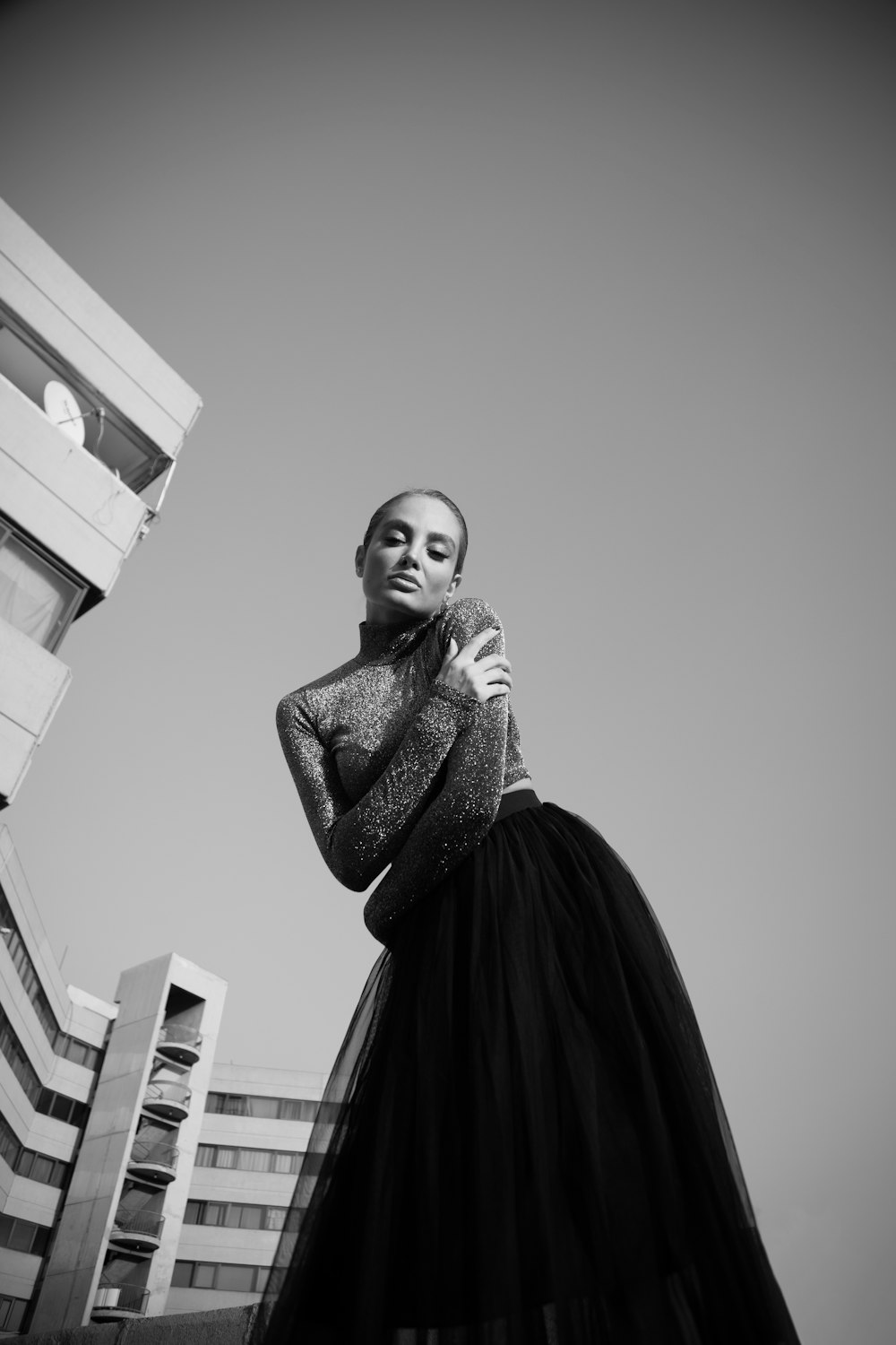 a woman in a long black dress standing in front of a building