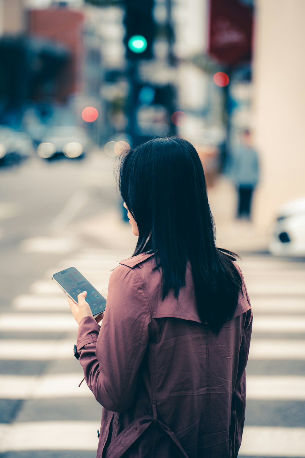 a woman standing on the side of a street holding a tablet