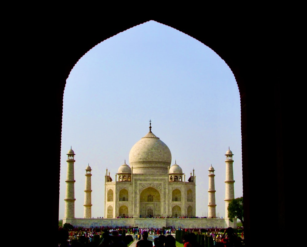 a view of a white building through an arch