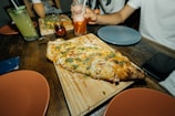 A rustic wooden table set with a variety of colorful pizzas ready to serve.