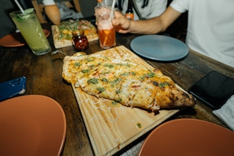 A rustic wooden table set with a delicious pizza and fresh ingredients.