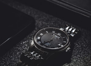 a watch sitting on top of a black table