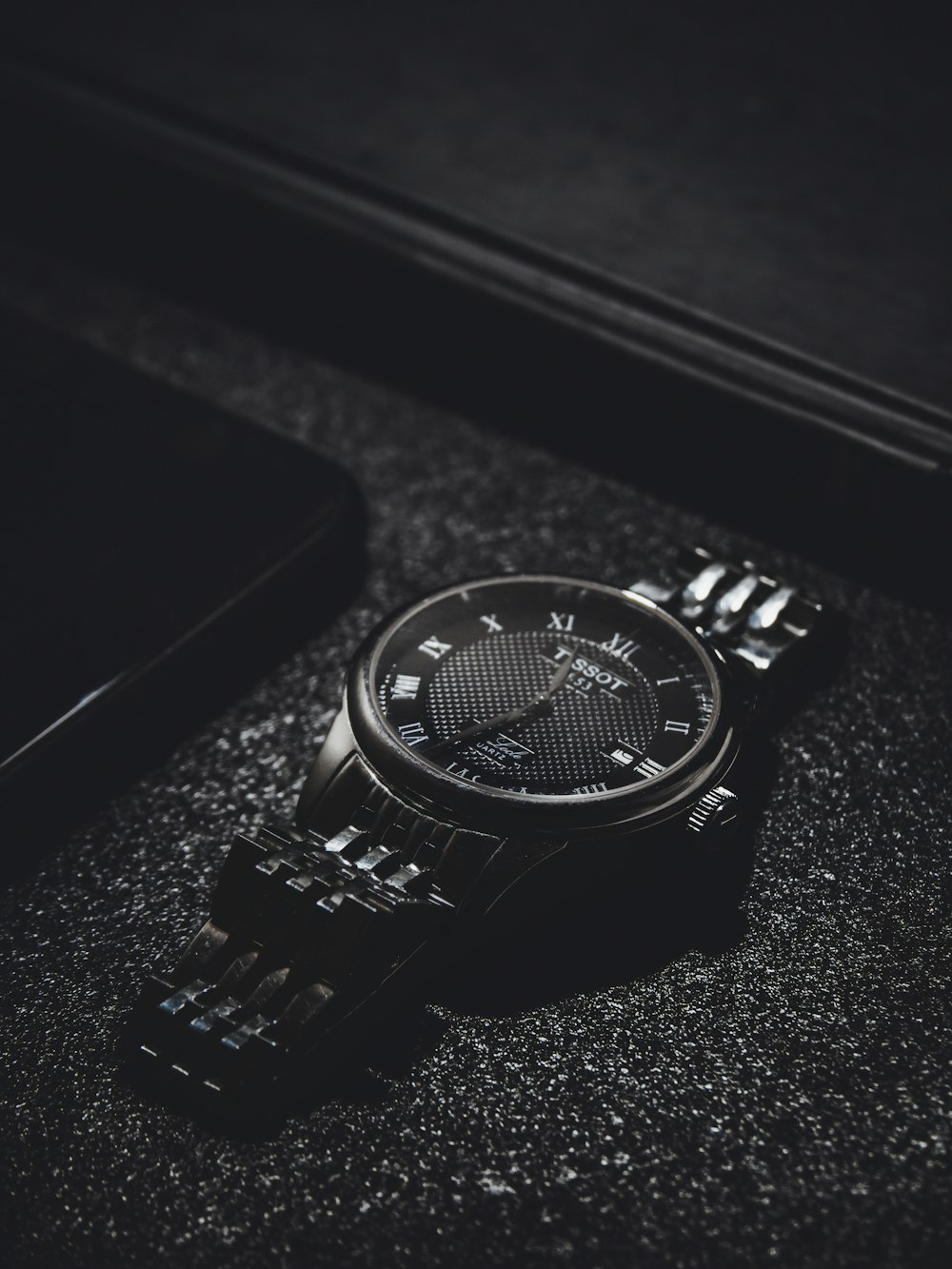 a watch sitting on top of a black table