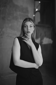 a black and white photo of a woman in a black dress