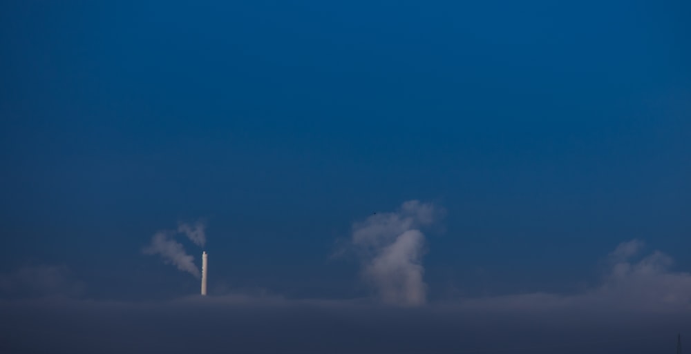 a plane flying in the sky with smoke coming out of it