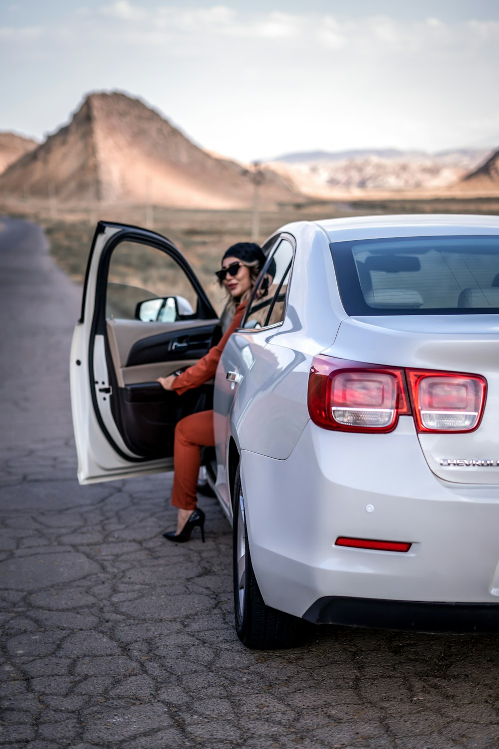 a woman sitting in the back of a white car