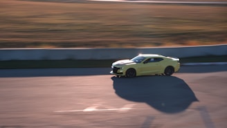 Close-up of a race car speeding on the track under bright sunlight.