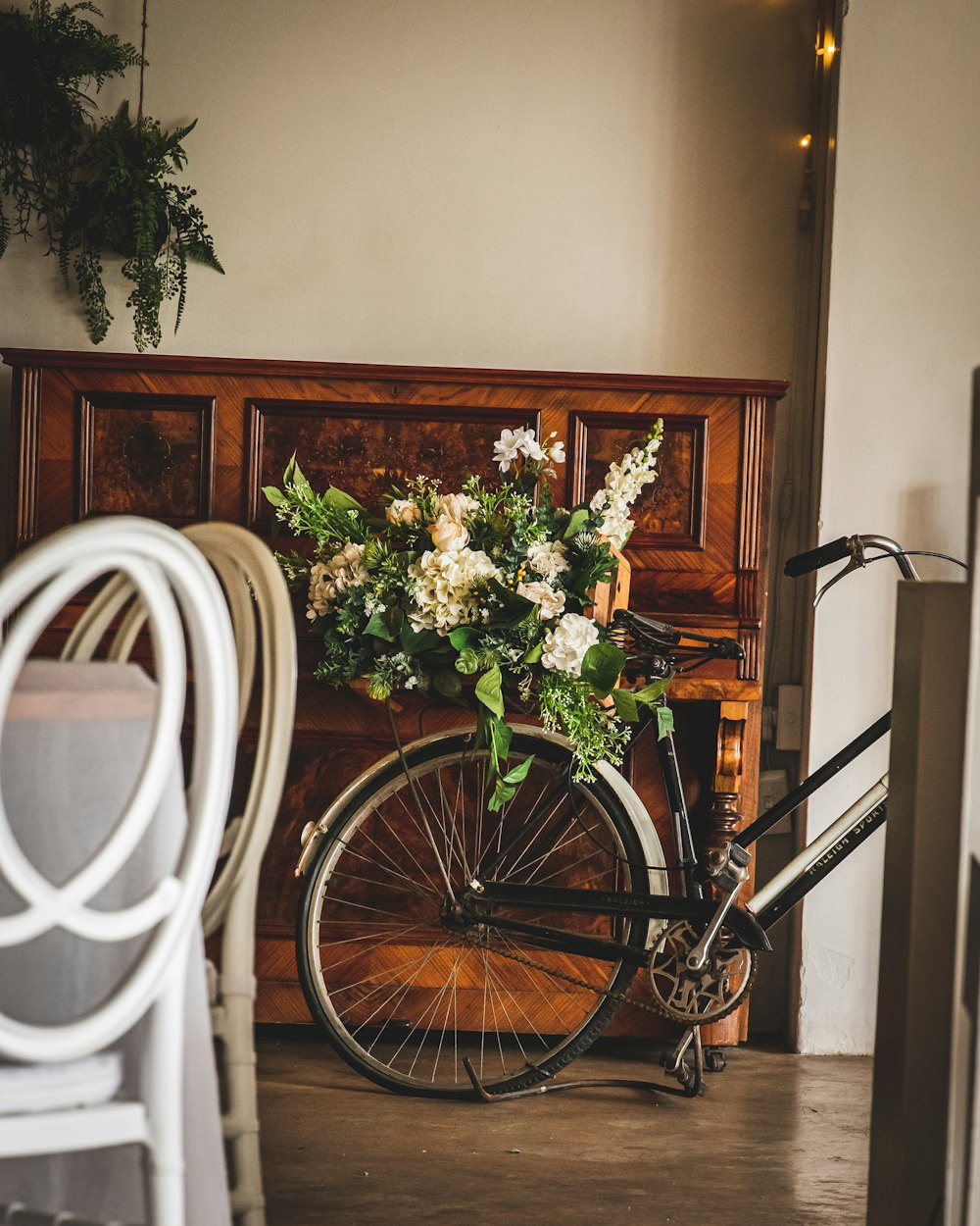 a bicycle parked next to a piano in a room