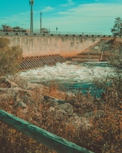 Close-up of grout injection equipment operating underwater near a dam structure.