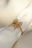Close-up of a delicate gold ring resting on a soft white fabric.