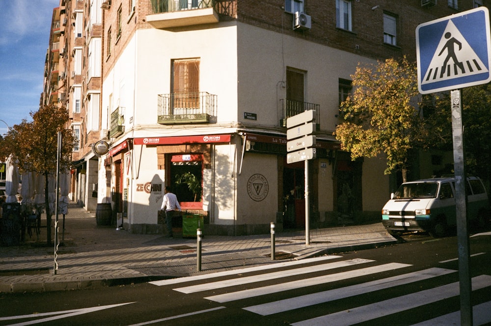 a street corner with a pedestrian crossing sign