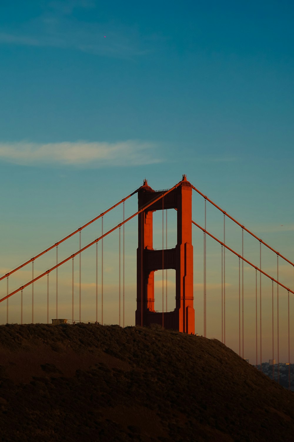 the golden gate bridge is silhouetted against a blue sky