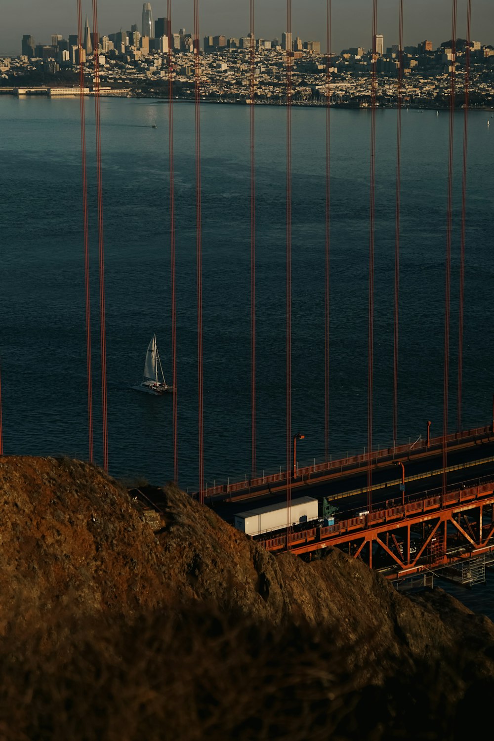 a view of the golden gate bridge with a sailboat in the water