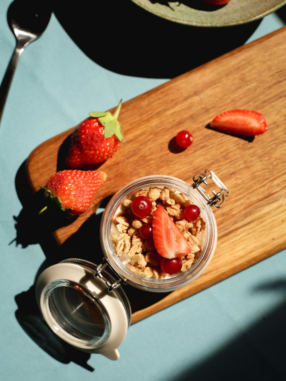 a wooden cutting board topped with a bowl of fruit