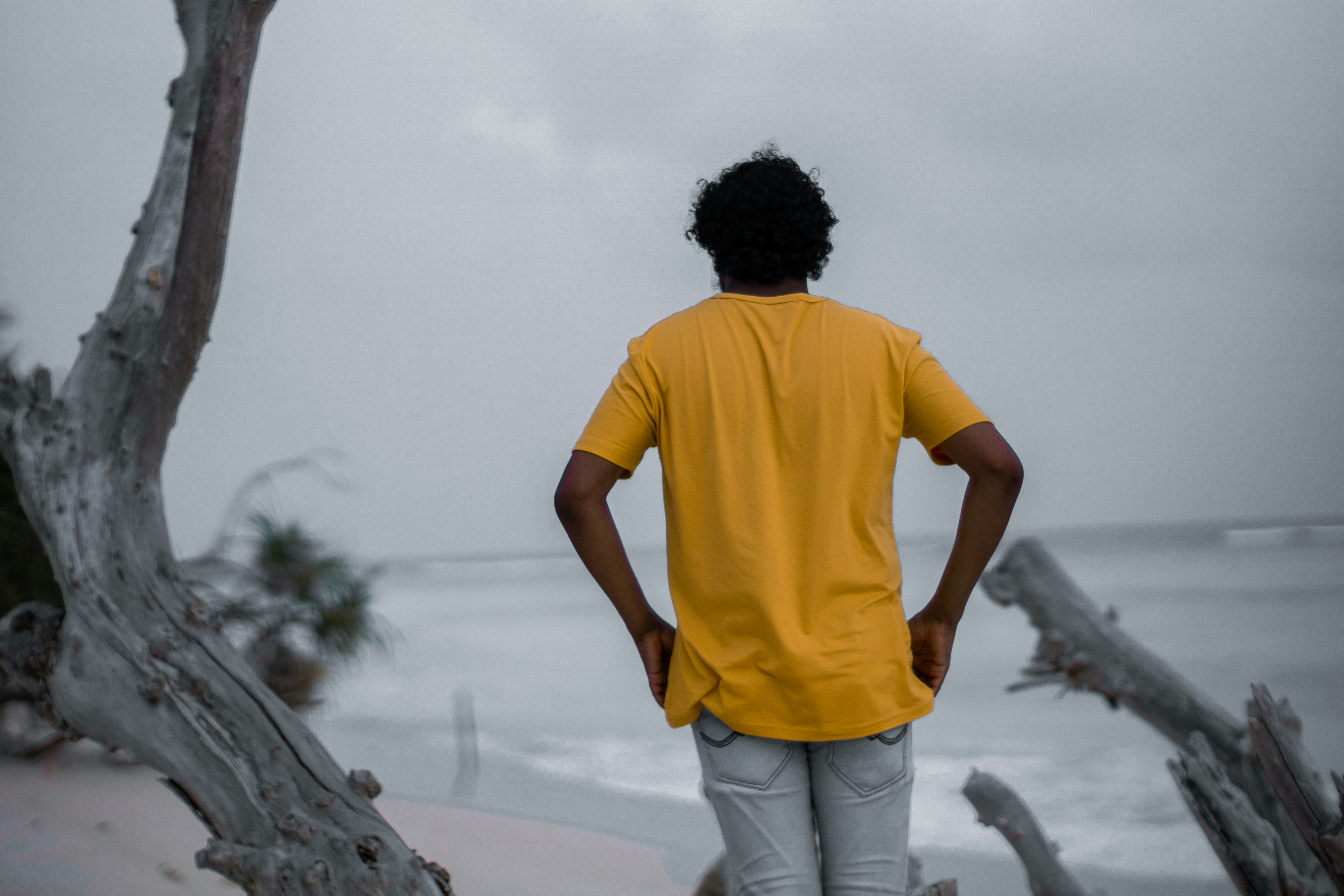 a man standing on a beach looking out at the ocean