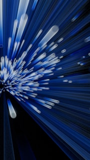 A dynamic display of blue and white light streaks emanates from a central point, creating a sense of motion and energy. The lines vary in length and intensity, giving the appearance of speed or acceleration.