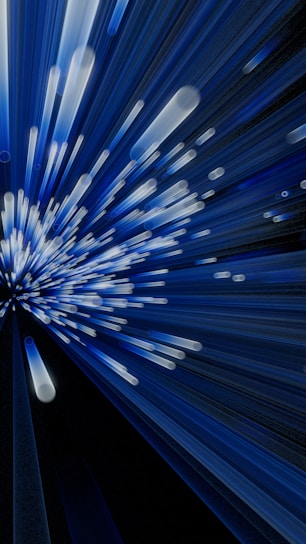A dynamic display of blue and white light streaks emanates from a central point, creating a sense of motion and energy. The lines vary in length and intensity, giving the appearance of speed or acceleration.